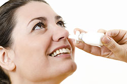 woman using nasal spray